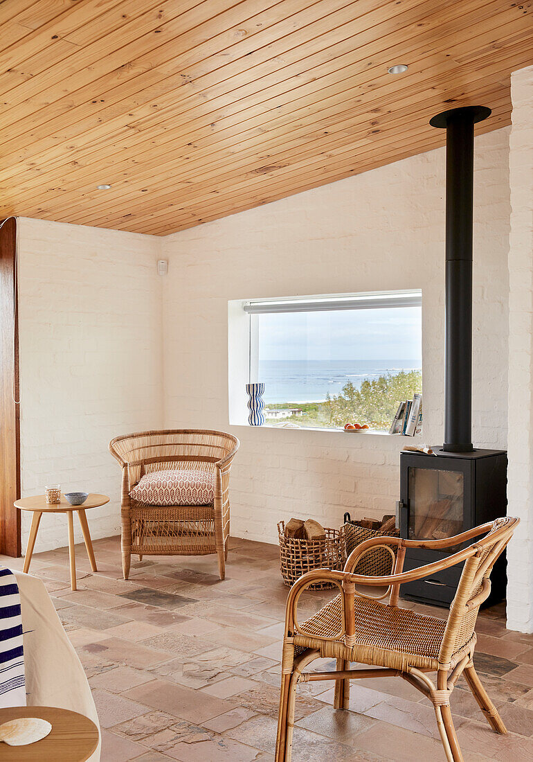 Lounge with rattan furniture, wood-burning stove and sea view