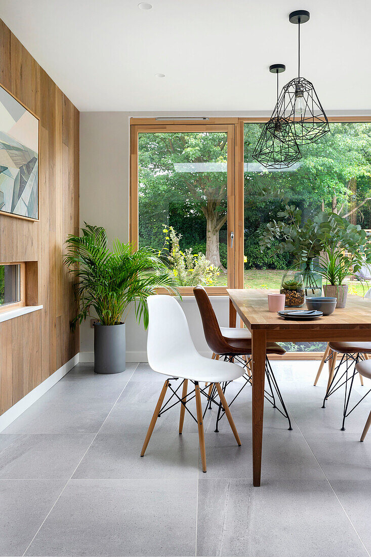 Bright dining area in front of oak plank wall paneling and patio door