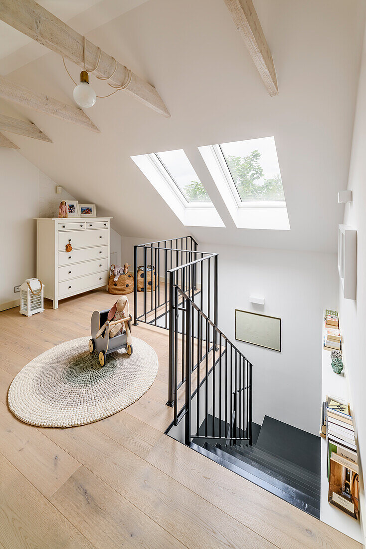 Playroom in an attic in a white, boho, rustic style, children's toys and staircase landing