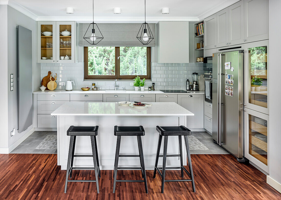 Weiß-graue Küche mit Kücheninsel in offenem Wohnraum