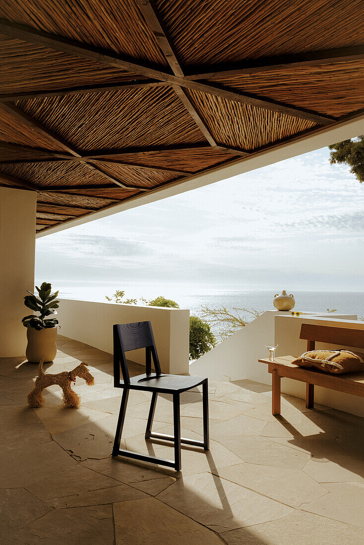 Partially covered terrace with natural stone floor and sea view