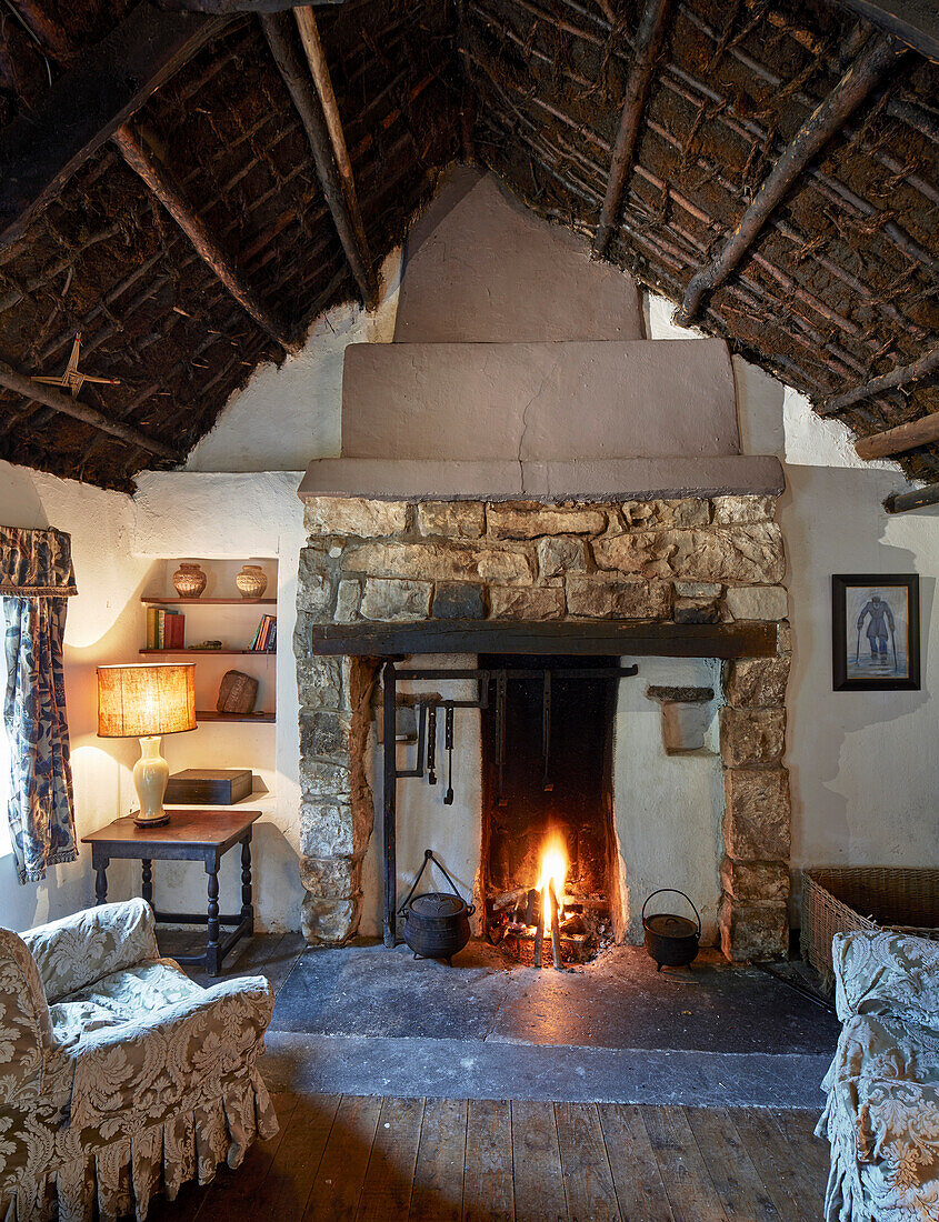 Rustikaler Wohnraum mit Kamin und Torfdach in traditionellem Bauernhaus, Irland