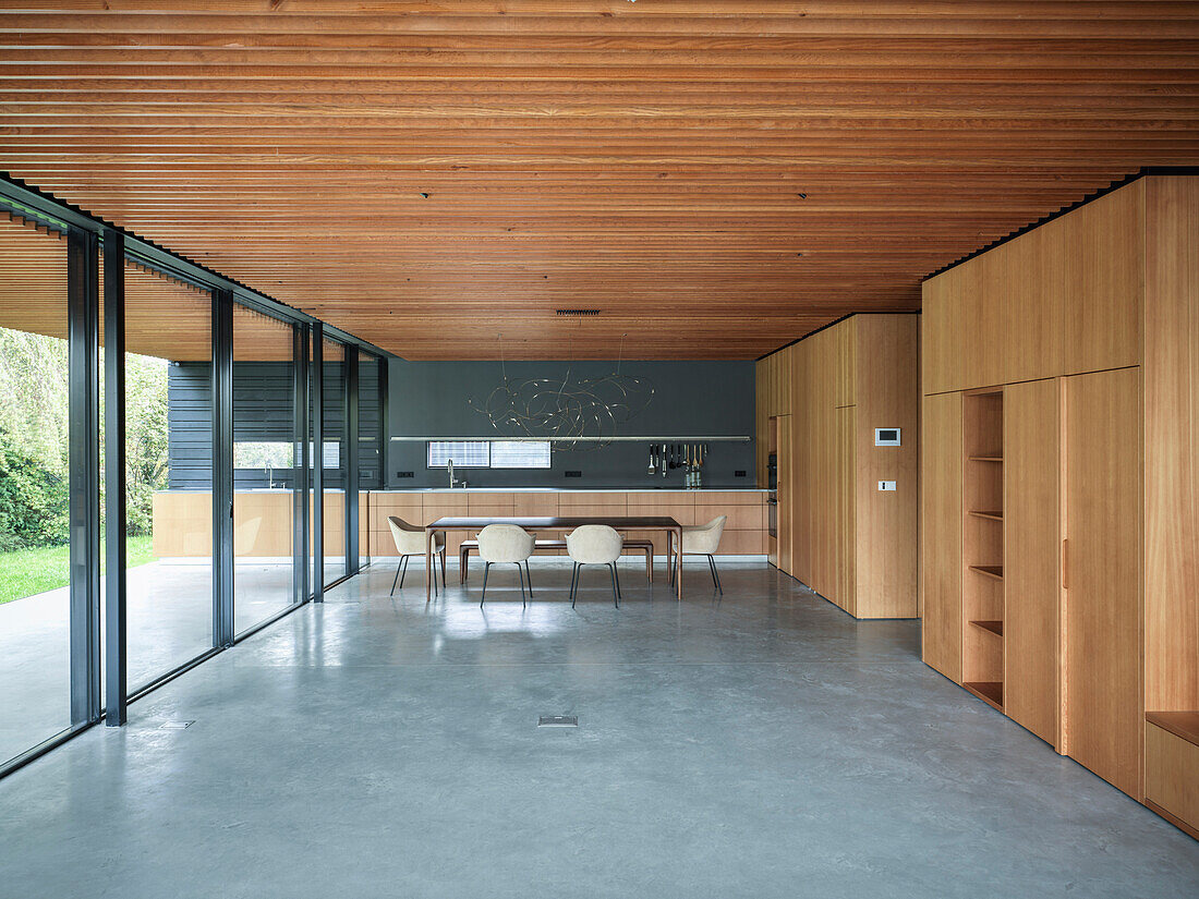 Open kitchen and dining area with wooden elements and concrete floor