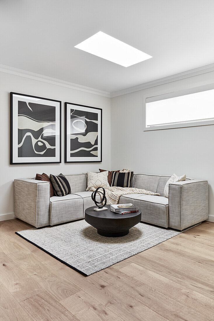 Modern living room in neutral tones with black, carved wood coffee table