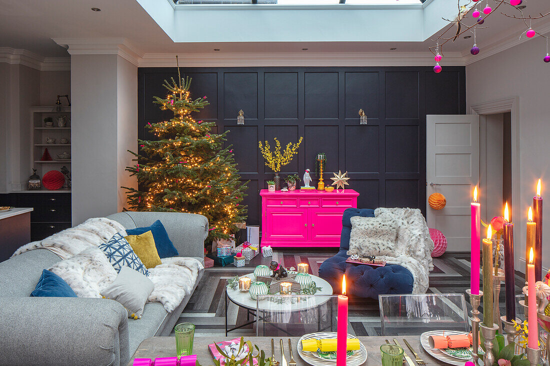 Weihnachtlich dekoriertes Wohnzimmer mit Tannenbaum und Kerzenlicht