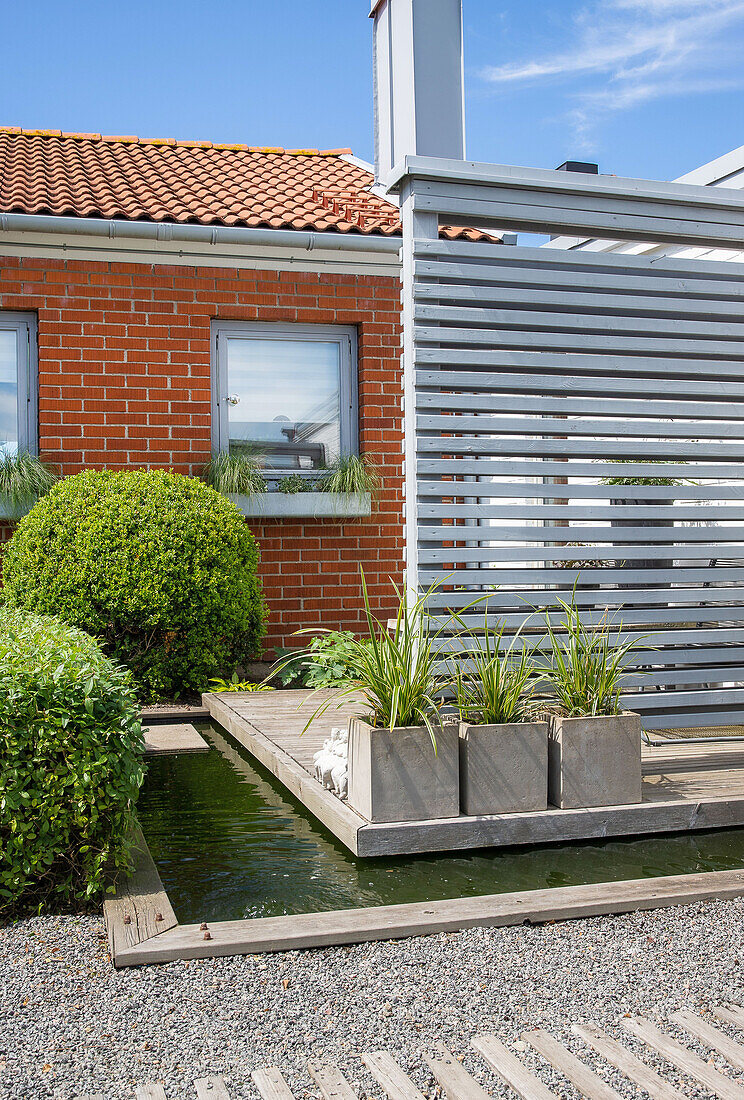 Terraced house terrace in Malmö with pond and privacy trellis