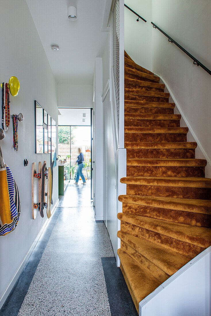 Hallway with terrazzo floor and stairs with brown carpet