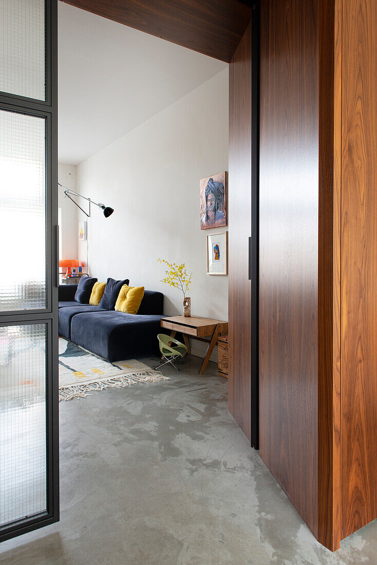 View of living room with concrete floor and blue sofa