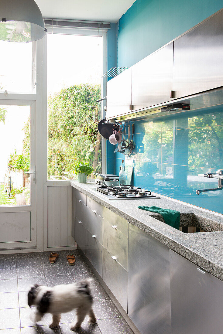 Modern kitchen with stainless steel fronts and view of the garden