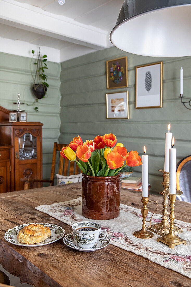 Dining table with bouquet of tulips and candles, vintage style