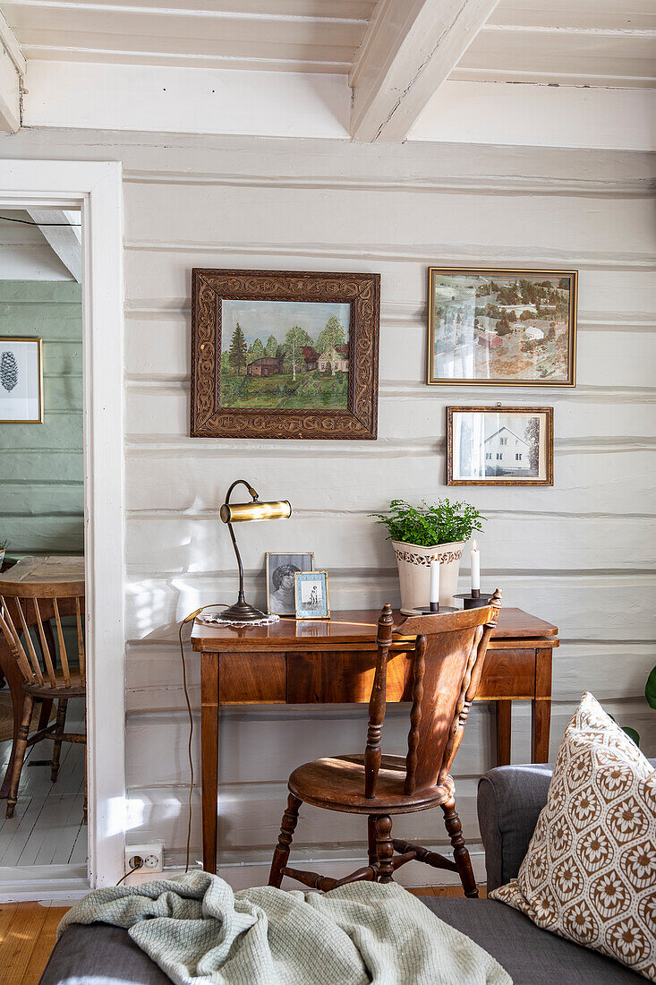 Wooden desk with reading lamp and wall pictures in living room