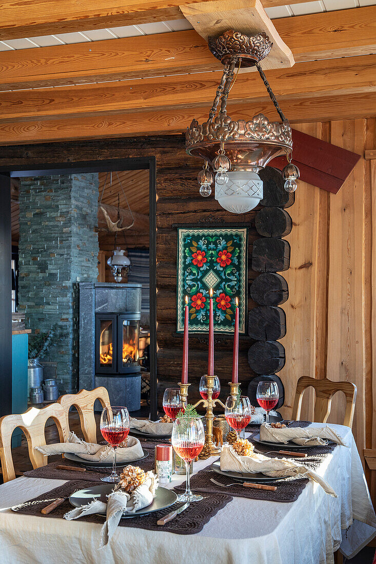 Festively set dining table with fireplace in rustic mountain hut