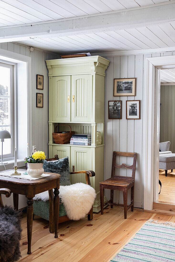 Bright room with green cupboard and wooden furniture