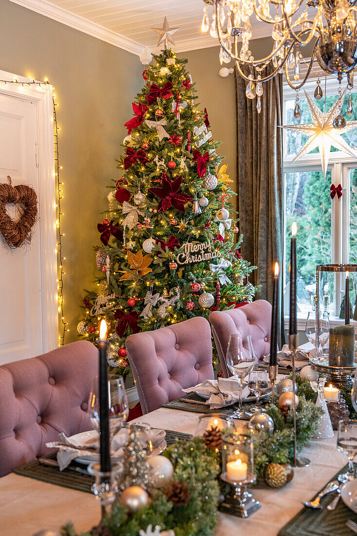 Festive dining table with Christmas tree and chandelier