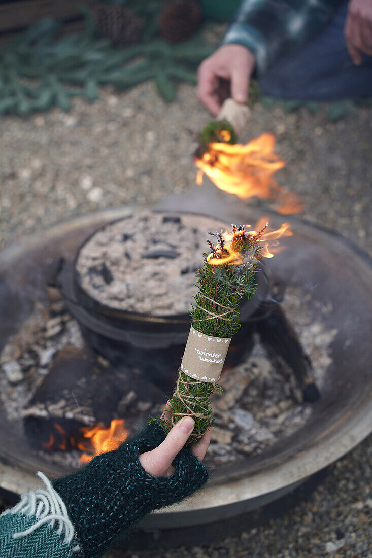 Räuchern, DIY Räucherbündel aus Wacholder- und Fichtenzweigen mit Banderole 'winter wishes' vor Feuerschale