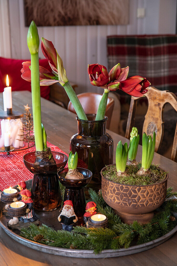 Weihnachtliche Tischdekoration mit Amaryllis, kleinen Figuren und Kerzen