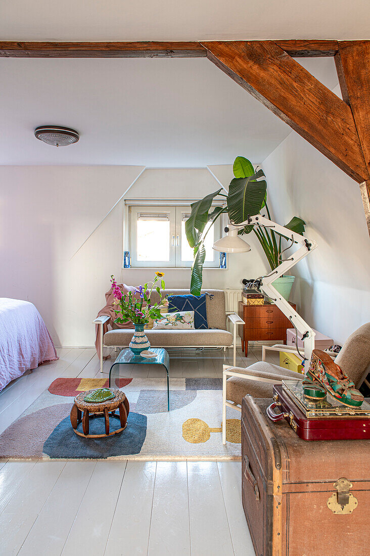 Room with patterned carpet, vintage furniture, flowers and plant