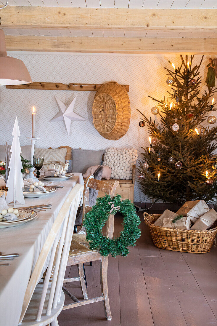 Weihnachtlich gedeckter Esstisch und geschmückter Tannenbaum