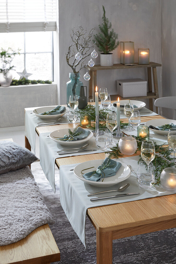 Festive dining table with light blue accents and candlelight in winter