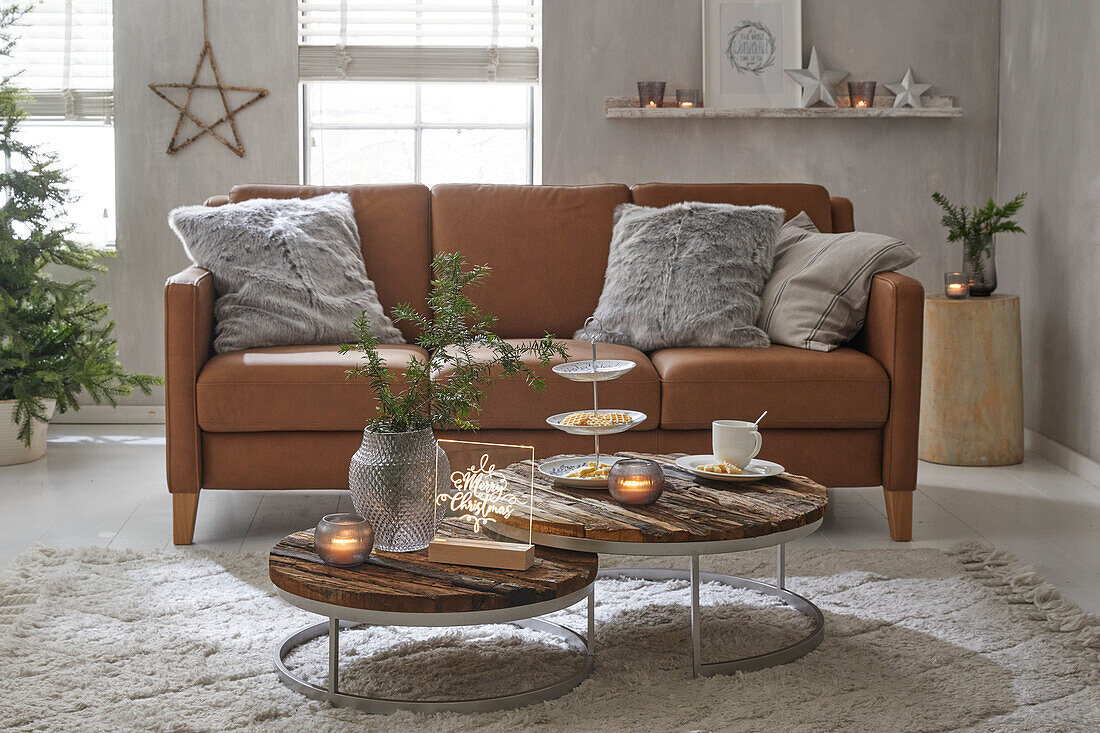 Wohnzimmer mit Ledersofa, Holz-Couchtischen und Weihnachtsdekoration