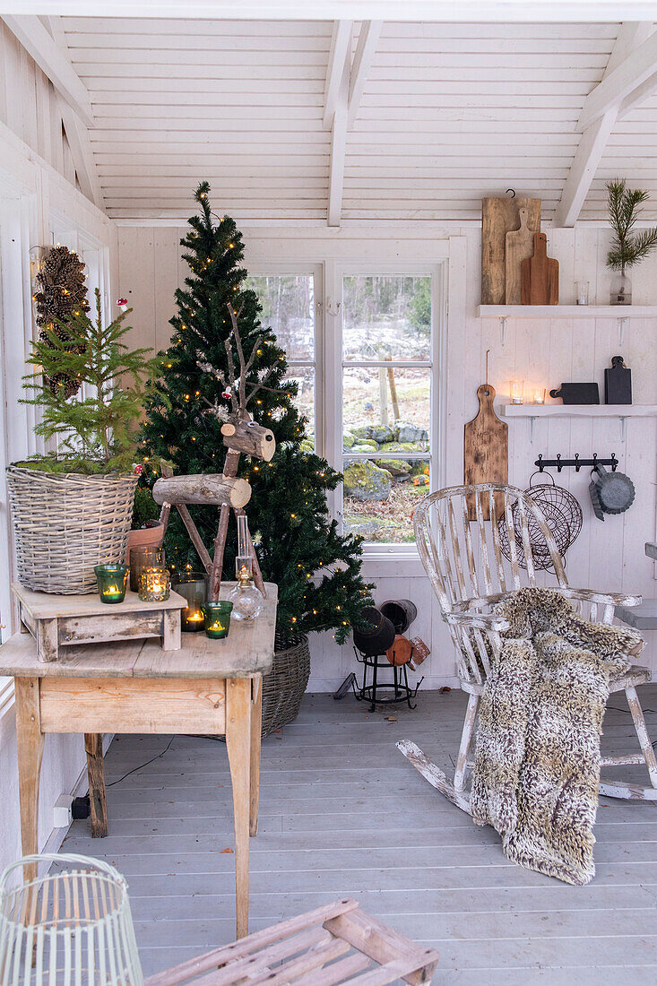 Weihnachtlich geschmückter rustikaler Raum mit Tannenbaum