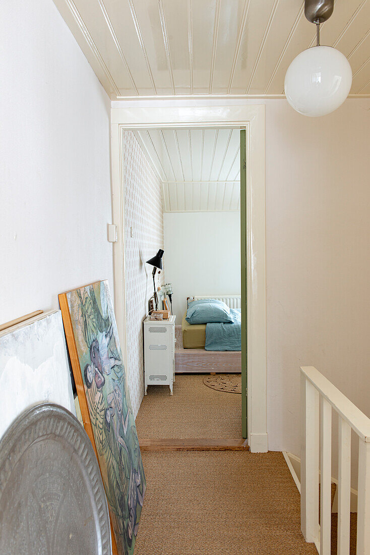 Hallway on the upper floor with sisal carpet and view of the bedroom