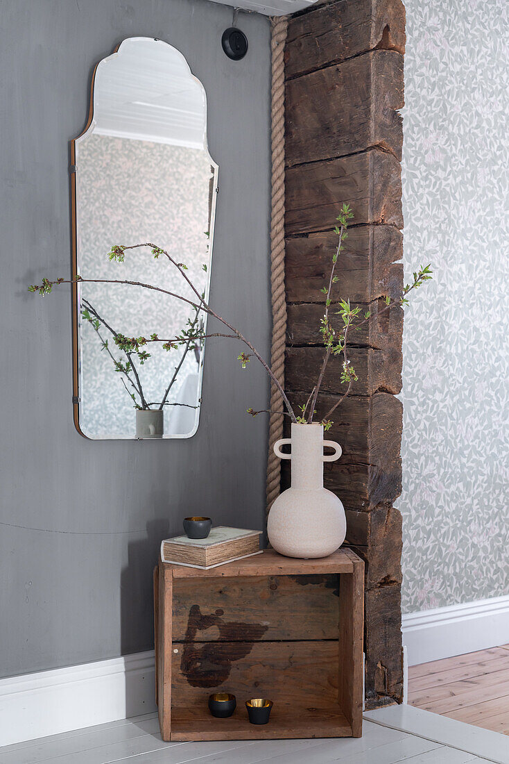 Rustic wooden box with vase and branches, large wall mirror