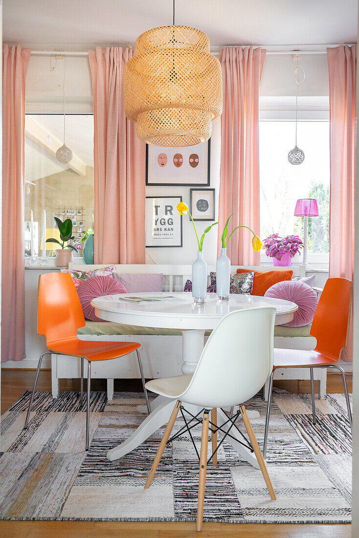 Dining room with white round table, hanging lamp and colourful accents