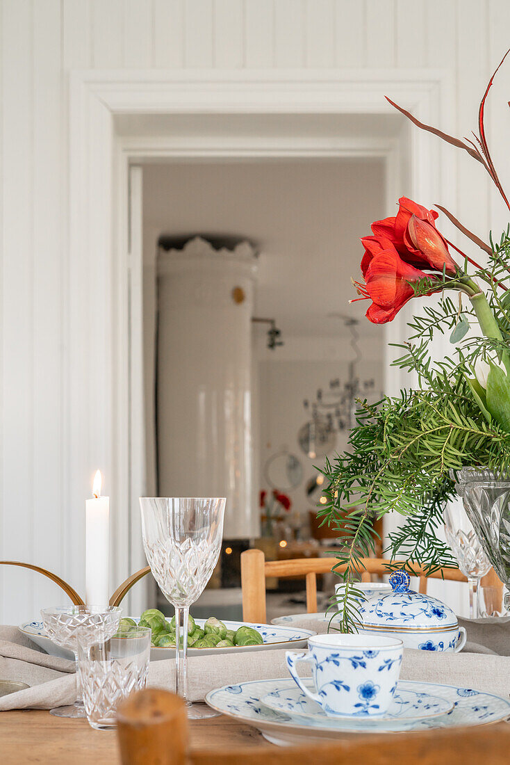 Gedeckter Tisch mit blau-weißem Geschirr und roten Amaryllis