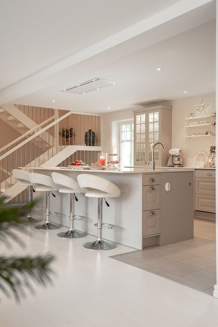 Modern kitchen with bar stools and integrated lighting