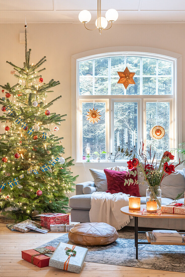 Weihnachtlich dekoriertes Wohnzimmer mit Tannenbaum und Geschenken