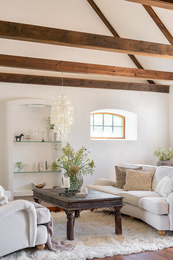 Bright living room with wooden beamed ceiling and vintage coffee table