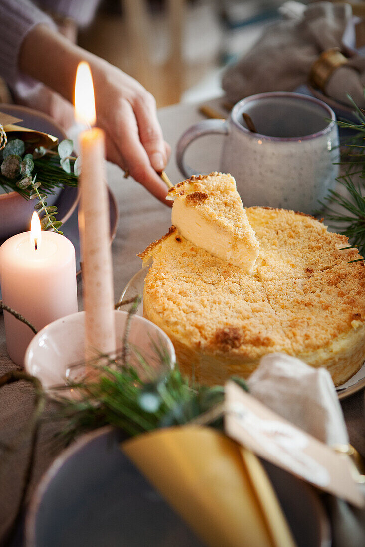 Portionierung eines Kuchens auf gedecktem Tisch mit Kerzenlicht