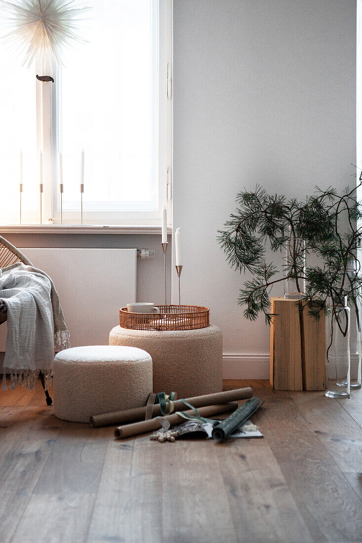 Poufs, tray and rolls of wrapping paper in a bright living room with natural decorations