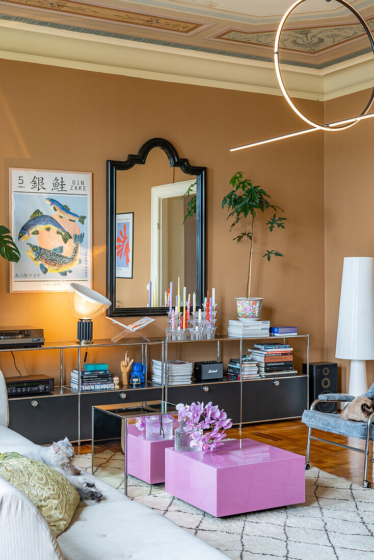 Living room with mirror, modern ceiling light and purple side table