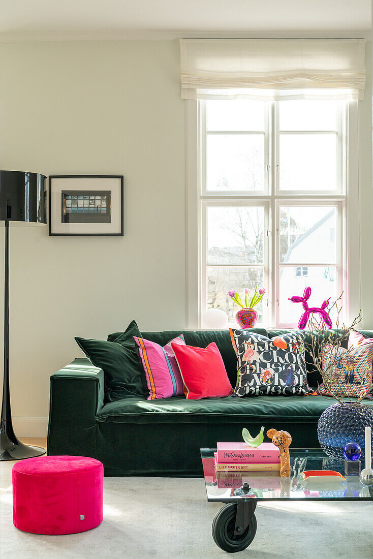 Modern living room with green velvet sofa and colourful decorative cushions