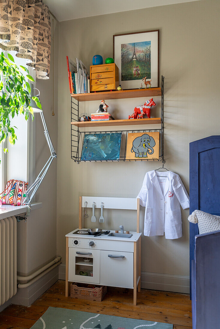 Children's room corner with play kitchen, wall shelf and creative decoration