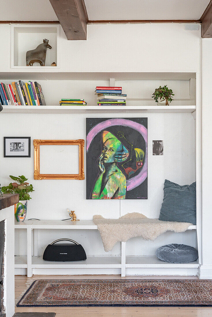 Bench, bookshelf and artwork on white wall