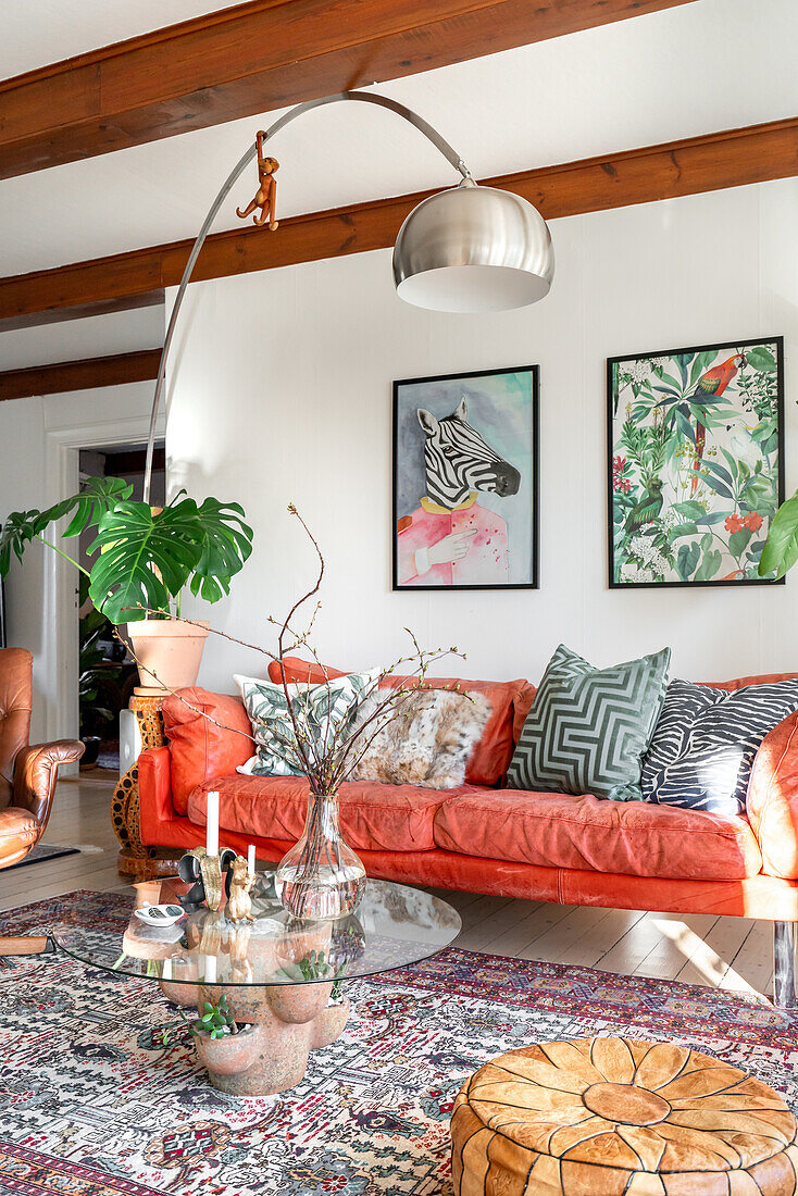 Living room with light red sofa, patterned carpet and green plants