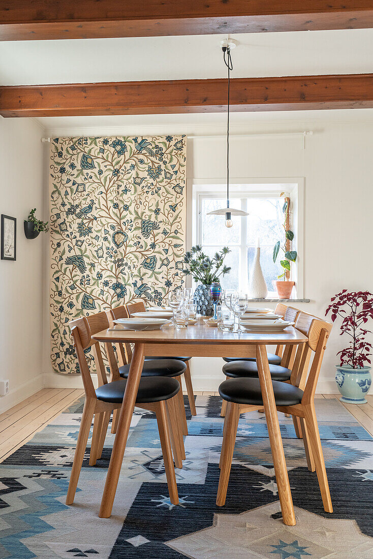 Set table, chairs, patterned curtain and patterned carpet in dining room