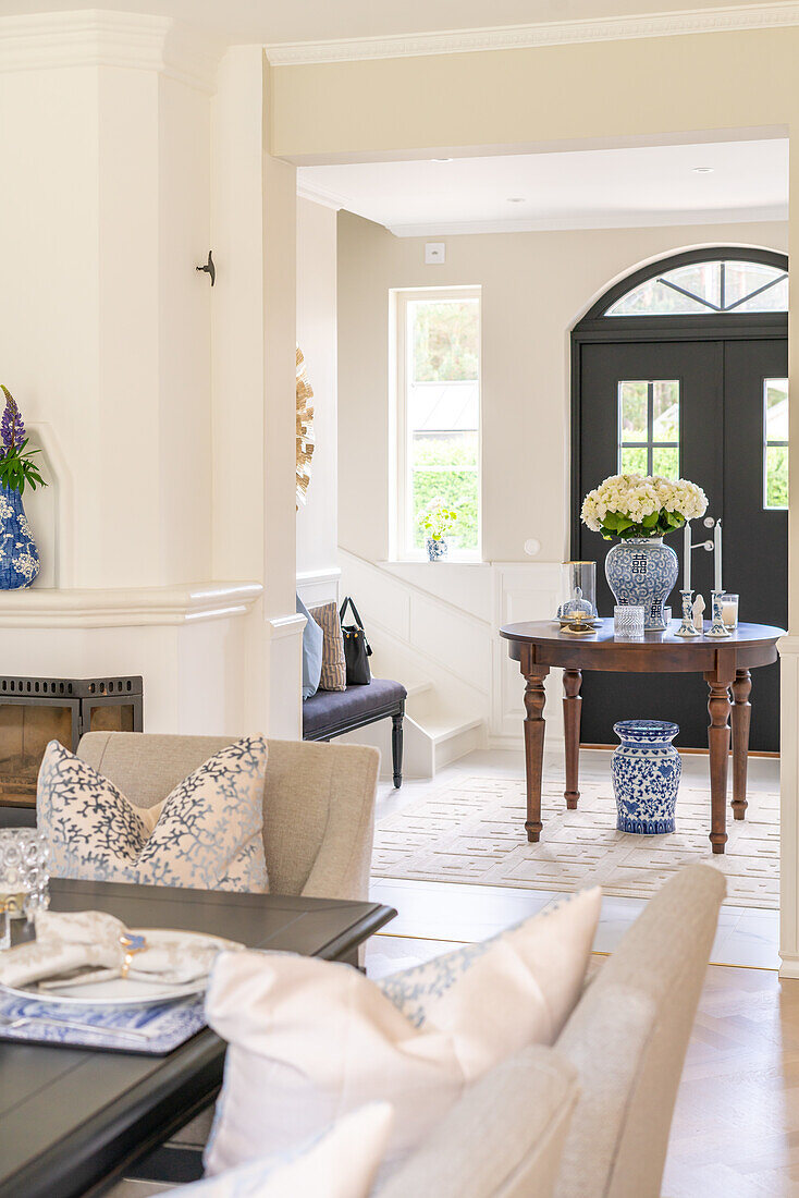 Entrance area with round table and floral decorations, light color scheme