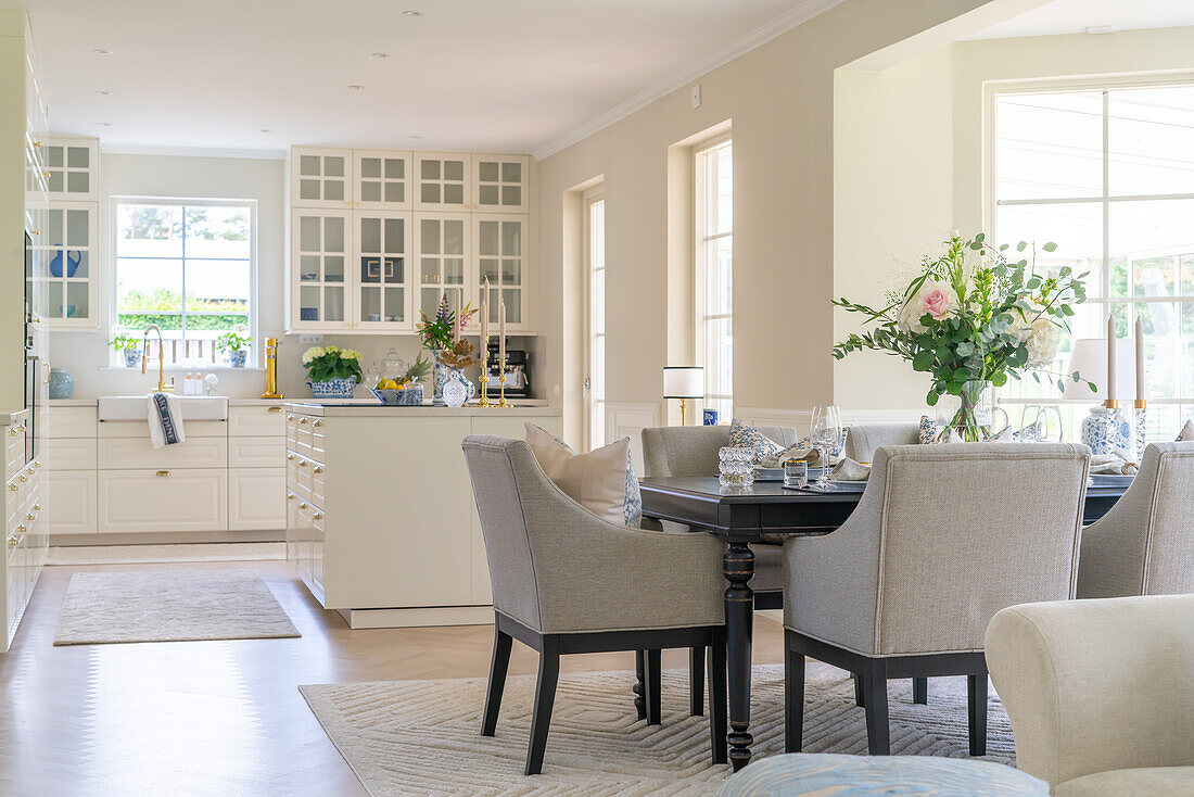 Open-plan living area with dining table and kitchen in white