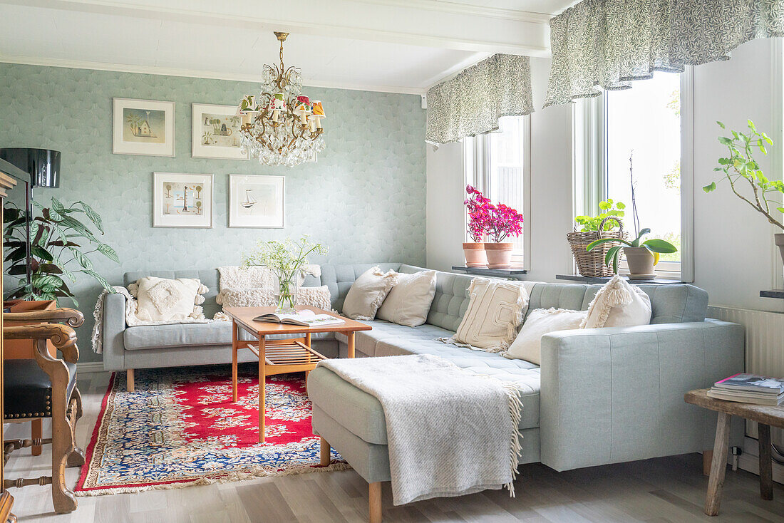 Bright living room with large corner sofa, red carpet and houseplants