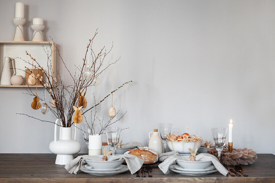 Minimalist table setting with simple white vases and dried flowers