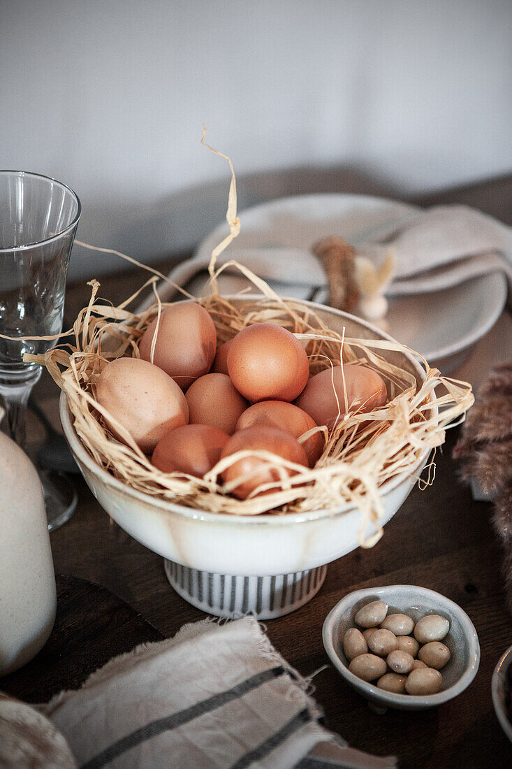 Bowl with eggs on a wooden table, plate and linen napkins