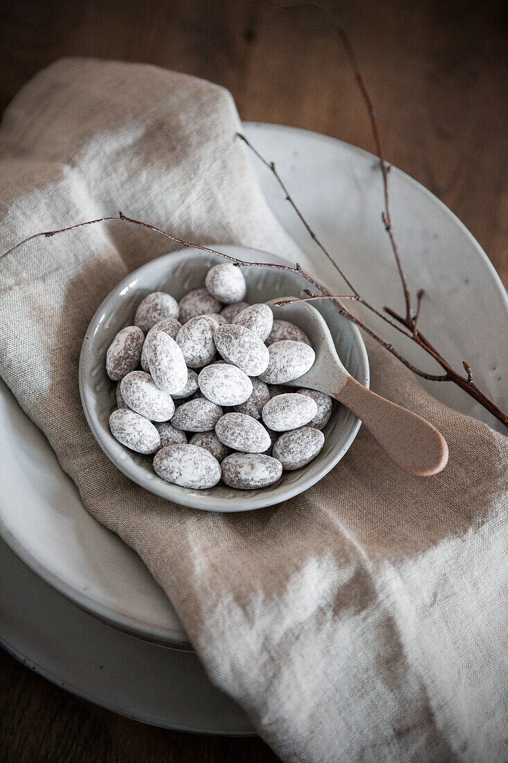 Bowl with sugared almonds on a rustic table setting