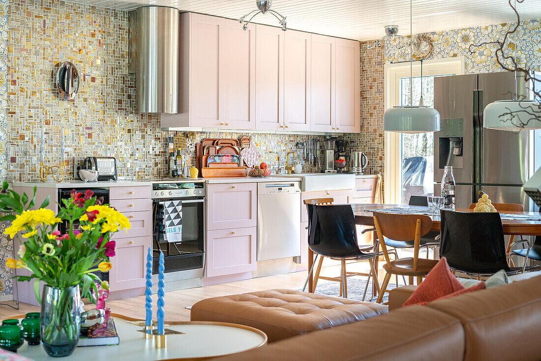 Kitchen with pink cabinets, mosaic tiles and wallpaper with floral pattern