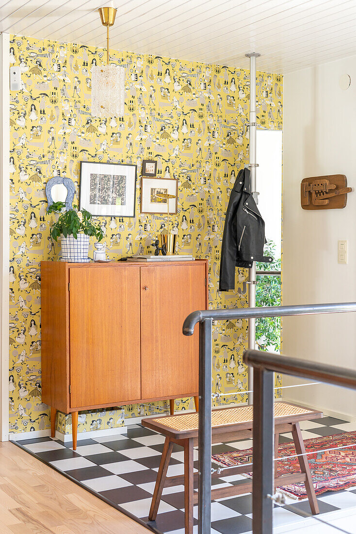 Hallway with yellow vintage wallpaper and retro sideboard