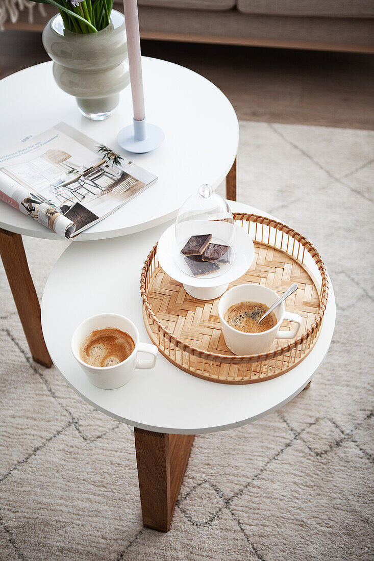 Zweistufiger weißer Couchtisch mit Kaffeegedeck