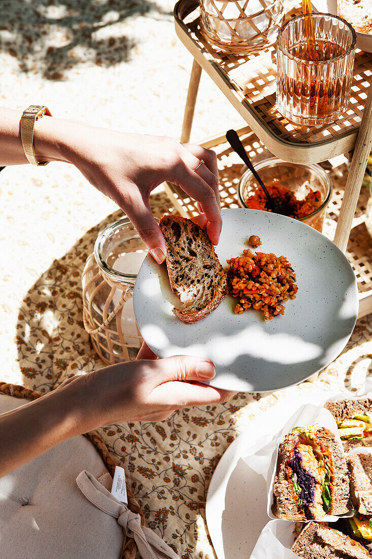 Sommerliches Picknick mit vegetarischen Sandwiches auf gemusterter Decke